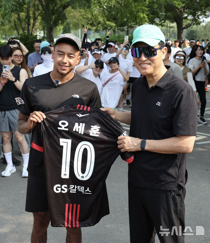 [서울=뉴시스] 김명년 기자 = 오세훈 서울시장이 1일 오전 서울 광진구 뚝섬한강공원에서 열린 쉬엄쉬엄 한강 3종 축제 10km 달리기 출발점에서 FC서울 소속 축구선수 제시 린가드에게 유니폼을 선물받은 뒤 기념촬영하고 있다. 2025.06.01. kmn@newsis.com