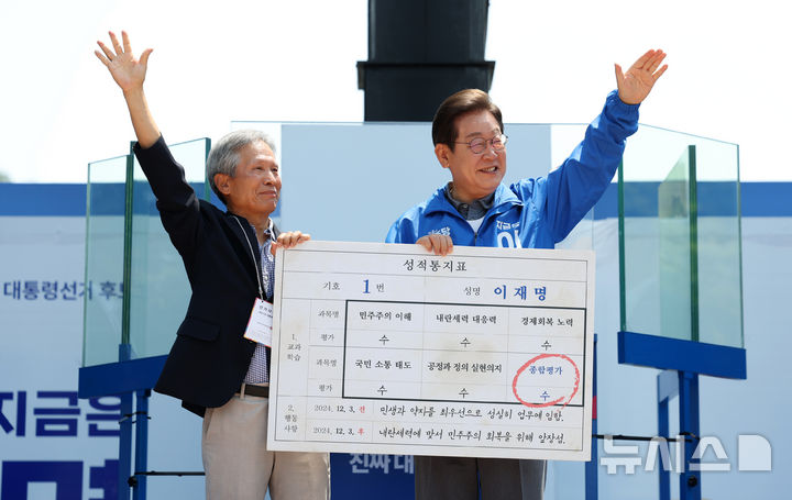 [안동=뉴시스] 조성우 기자 = 이재명 더불어민주당 대선후보가 1일 오전 경북 안동시 웅부공원에서 열린 유세에서 이 후보의 초등학교 은사인 박병기 씨로부터 대선 후보 모의 성적통지표를 받고 기념촬영하고 있다. 2025.06.01. xconfind@newsis.com