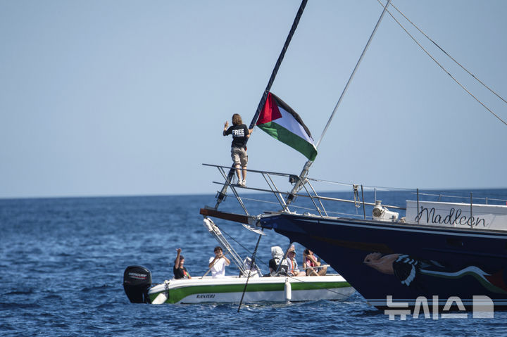 [AP/뉴시스] 지난 1일 그레타 툰베리가 가자 지구 구호 물품을 실은 마드린호에서 팔레스타인 국기 옆에 올라 서 있다. 