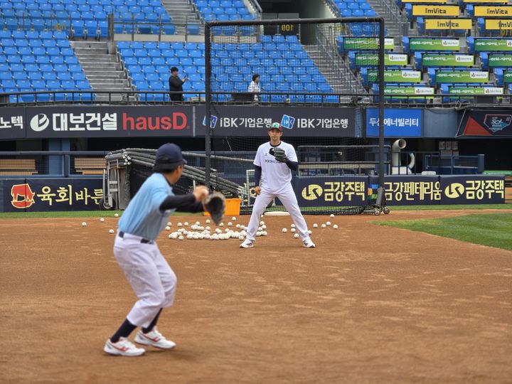 [서울=뉴시스]두산 베어스 타자 강승호가 2일 서울 잠실구장에서 열린 야구클리닉 '두드림'에 참가한 유소년 선수의 공을 받고 있다. (사진=&nbsp; 한국프로야구선수협회 제공) 2025.06.02. photo@newsis.com *재판매 및 DB 금지