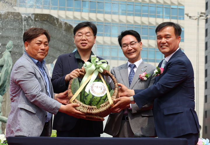 [고창=뉴시스] 지난달 31일 서울 신세계백화점 본점 광장에서 열린 고창수박 판촉행사 중 명품수박 경진대회의 1등 수박이 이어진 경매에서 역대 최고가 500만원에 낙찰됐다. 심덕섭 군수(왼쪽 세번째)와 조민규 군의장(왼쪽 네번째)이 낙찰자와 함께 기념사진을 찍고 있다. *재판매 및 DB 금지