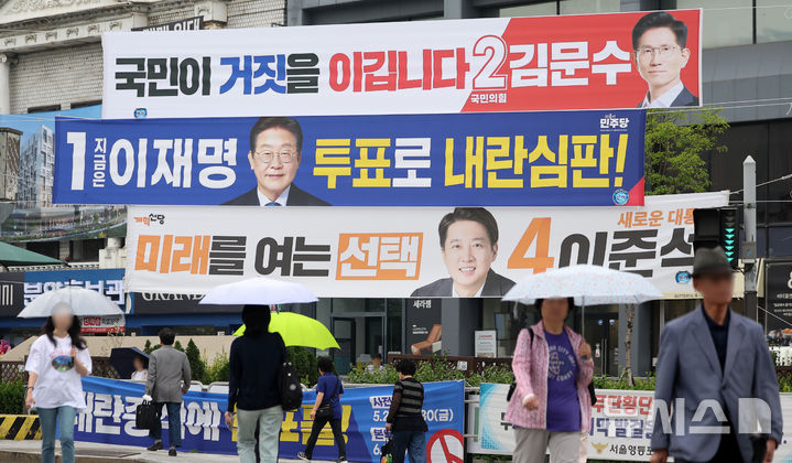 [서울=뉴시스] 김선웅 기자 = 지난 2일 서울 영등포구 한 교차로에서 시민들이 대선 후보 현수막 앞을 지나고 있다. 2025.06.02. mangusta@newsis.com