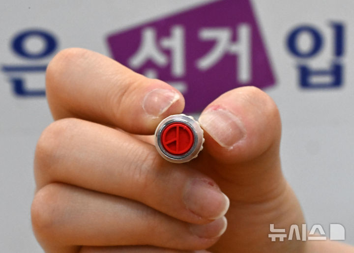 [서울=뉴시스] 김명년 기자 = 제21대 대통령 선거를 하루 앞둔 지난해 6월 2일 서울 용산구 청파도서관에 마련된 청파동 제1투표소에서 관계자가 기표 도장을 들어 보이고 있다.(공동취재) 2025.06.02. kmn@newsis.com