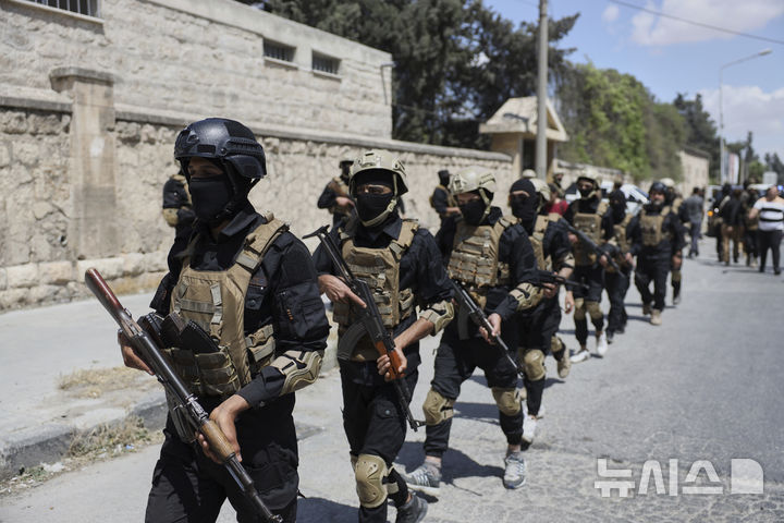 [알레포=AP/뉴시스]  시리아 알레포에서  6월 2일 시리아 과도정부와 쿠르드 주도 시리아민주군(SDF) 간 포로 교환이 진행되는 가운데, 정부 보안군 요원들이 주변을 순찰하고 있다. 이날 양측은  총 470명의 포로를 교환했지만 시리아의 치안 상태는 IS잔당의 기습등으로 여전히 불안한 것으로 전해졌다. 2025. 12.15.