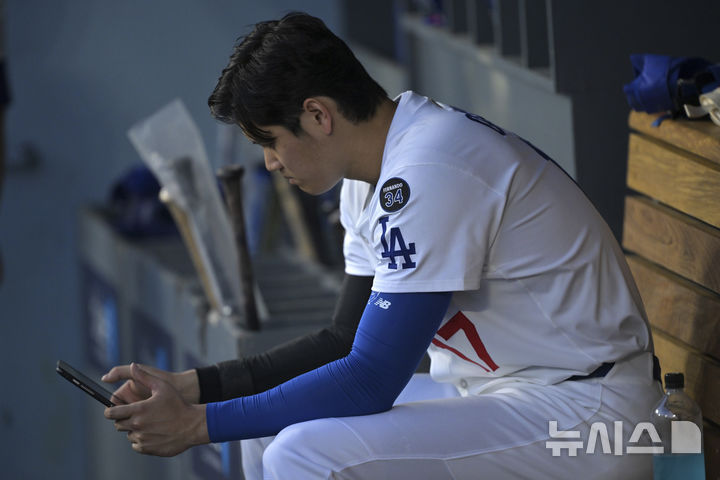 [로스앤젤렛,=AP/뉴시스] 더그아웃에서 태블릿PC를 확인하는 LA 다저스의 오타니 쇼헤이. 2025.06.03