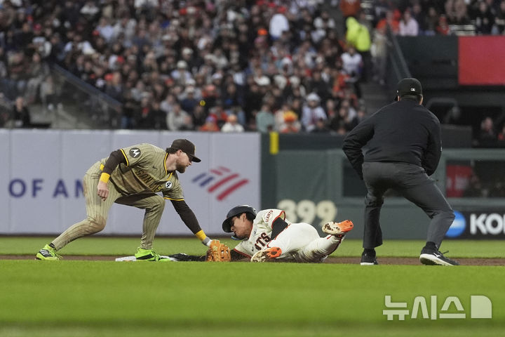 San Francisco Giants' Jung Hoo Lee, middle, steals second base against San Diego Padres second baseman Jake Cronenworth, left, during the sixth inning of a baseball game in San Francisco, Monday, June 2, 2025. (AP Photo/Jeff Chiu)