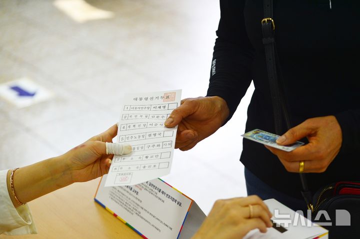 [청주=뉴시스] 서주영 기자 = 21대 대통령 선거일인 3일 충북 청주시 서원구 산남동행정복지센터에 마련된 투표소에서 한 시민이 투표용지를 건네받고 있다. 2025.06.03. juyeong@newsis.com