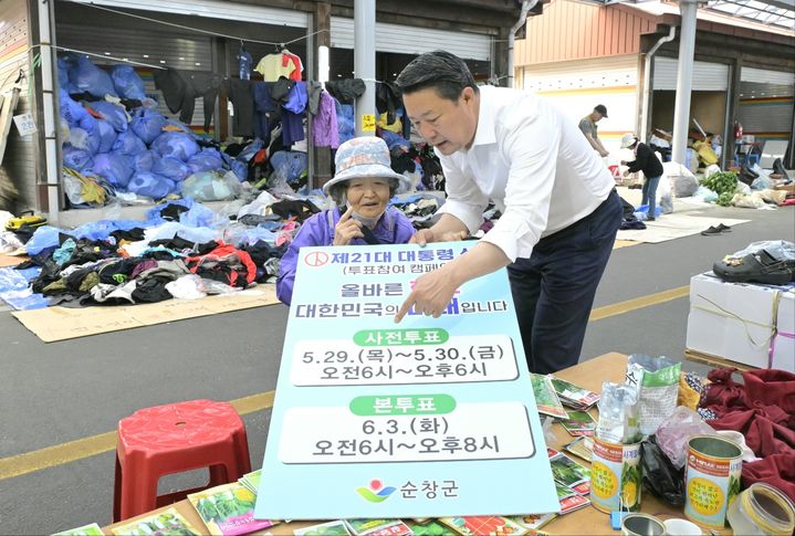 [순창=뉴시스] 제21대 대통령선거 투표참여를 독려하기 위해 순창전통시장을 찾은 최영일 군수가 한 주민에게 사전투표 일정을 설명하고 있다. *재판매 및 DB 금지