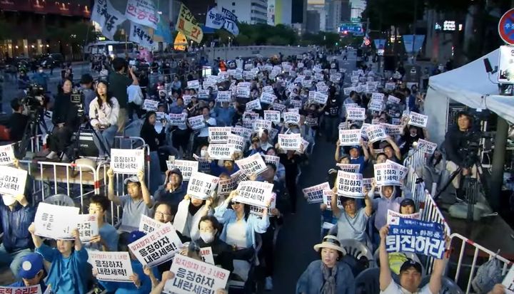 서울 중구 청계광장에서 집회를 열고 대선 개표방송을 지켜보던 진보 성향 시민단체인 촛불행동은 출구조사 결과가 나온 뒤 피켓을 들고 기뻐하고 있다.(사진=촛불행동 유튜브 캡처) *재판매 및 DB 금지