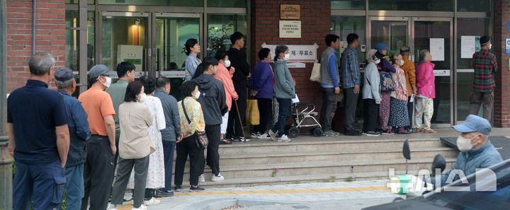 [전주=뉴시스] 김얼 기자 = 제21대 대통령선거일인 3일 전북 전주시 완산구 평화1동 제2투표소(전주남중학교)를 찾은 시민들이 투표를 하기 위해 줄지어 서 있다. 2025.06.03. pmkeul@newsis.com