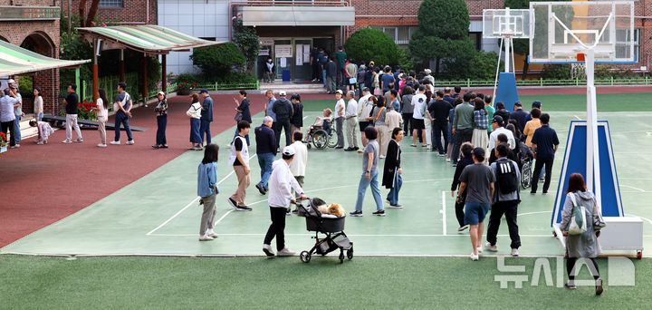 [서울=뉴시스] 박주성 기자 = 제21대 대통령선거일인 3일 오전 서울 서초구 원명초등학교에 마련된 서초4동 제3투표소와 제4투표소에 시민들을 투표하기 위해 줄을 서고 있다. 2025.06.03. park7691@newsis.com