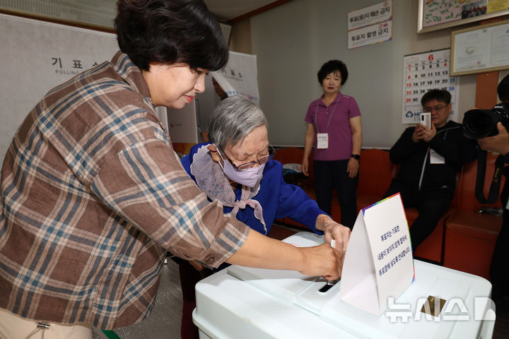 [광주=뉴시스] 박기웅 기자 = 제21대 대통령선거 본투표날인 3일 오전 광주 동구 최고령 유권자인 김정자(109·여)씨가 계림경로당(계림1동 제2투표소)에서 딸의 도움을 받아 투표를 하고 있다. 2025.06.03. pboxer@newsis.com