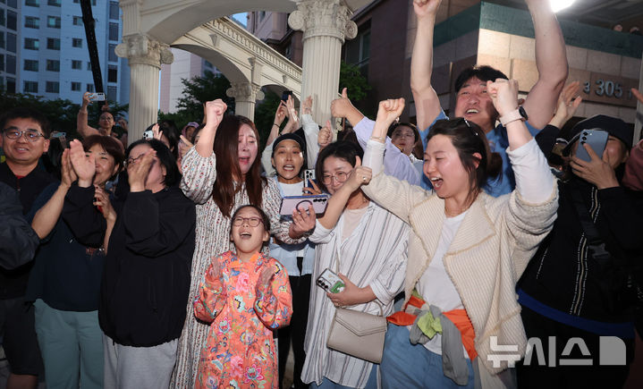 [인천=뉴시스] 전진환 기자 = 제21대 대통령 선거가 종료된 3일 오후 인천 계양구의 이재명 더불어민주당 후보의 자택 아파트 주민들이 방송사 출구조사 결과를 보며 환호하고 있다. 2025.06.03. amin2@newsis.com