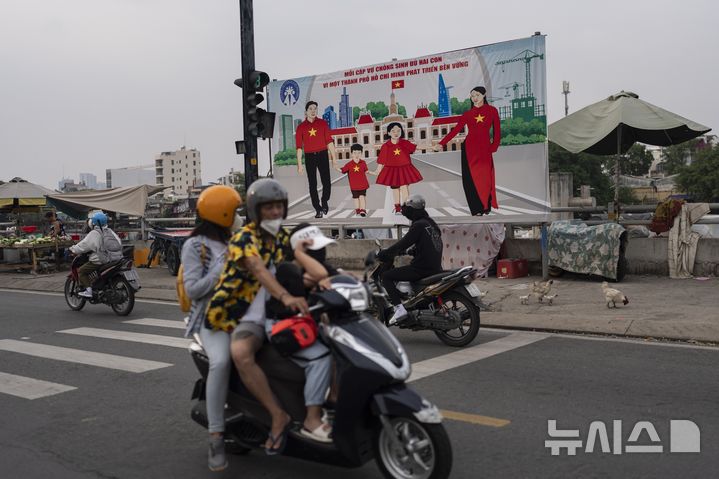 [호치민시티(베트남)=AP/뉴시스]2024년 1월14일 베트남 호치민시티는 출산율 제고를 위해 각 가정이 두 자녀를 갖자는 광고판이 세워져 있다. 베트남이 3일 오랫동안 지속해온 2자녀 제한을 폐지했다. 이는 감소하는 출산율을 되돌리고, 인구 고령화 사회의 부담을 완화하기 위한 것이다. 2025.06.04.