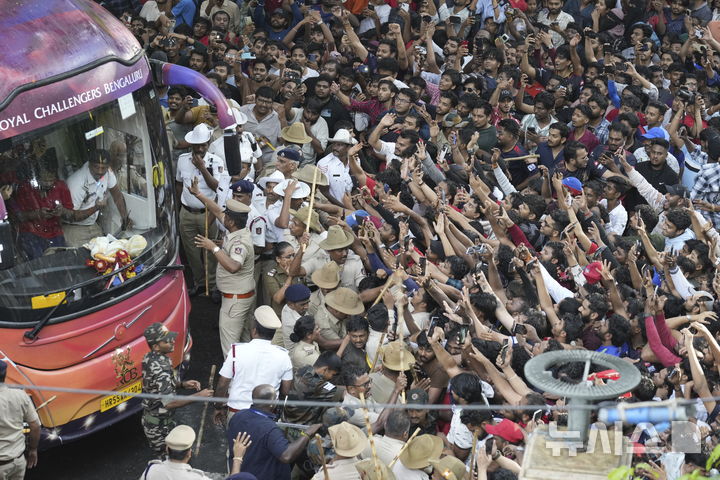[AP/뉴시스] 4일 인도 벵갈루루에서 크리켓 팬들이 리그 우승의 홈팀 퍼레이드 버스가 오자 선수들을 보기 위해 버스 쪽으로 쏠려들고 있다