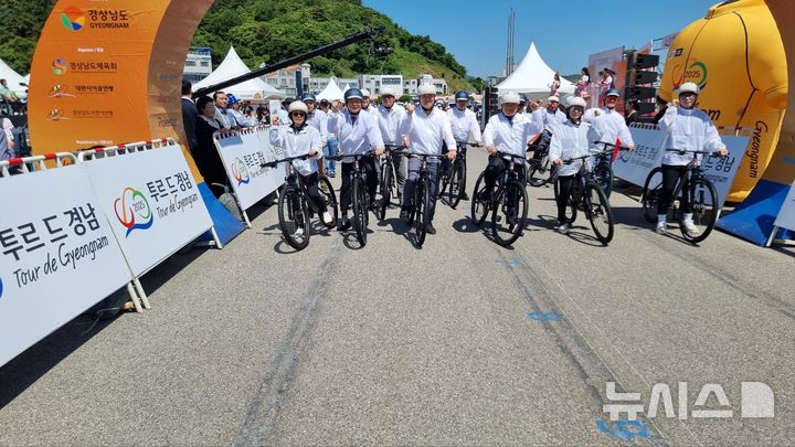 [통영=뉴시스]4일 오전 경남 통영 트라이애슬론 광장에서 열린 경남도 등 주최 '투르 드 경남 2025' 개막식에 참석한 주요 인사들이 대회 시작을 알리는 의미로 자전거 출발 퍼포먼스를 하고 있다.(사진=경남도 제공) 2025.06.04. photo@newsis.com