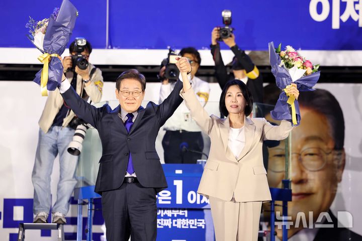 [서울=뉴시스] 조성우 기자 = 이재명 대통령과 김혜경 여사가 4일 오전 서울 여의도 국회 앞에서 열린 국민 개표방송 행사에서 꽃다발을 받은 뒤 시민들에게 인사하고 있다. 2025.06.04. xconfind@newsis.com
