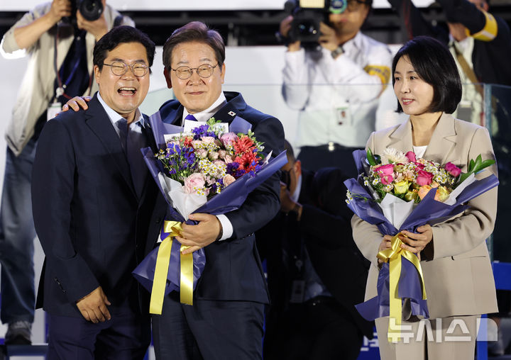 [서울=뉴시스] 조성우 기자 = 이재명 대통령이 지난해 6월4일 오전 서울 여의도 국회 앞에서 열린 국민 개표방송 행사에서 박찬대 더불어민주당 상임 총괄선거대책위원장에게 꽃다발을 받고 인사하고 있다. 2025.06.04. xconfind@newsis.com