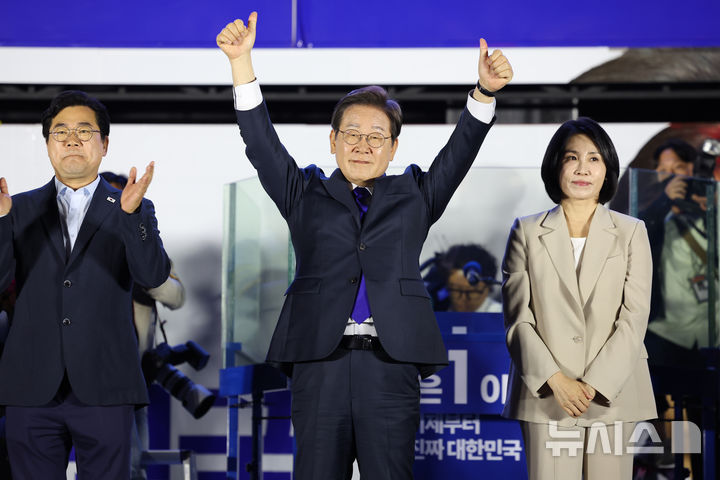 [서울=뉴시스] 조성우 기자 = 이재명 대통령이 4일 오전 서울 여의도 국회 앞에서 열린 국민 개표방송 행사에서 시민들에게 인사하고 있다. 왼쪽부터 박찬대 상임 총괄선대위원장, 이 대통령, 김혜경 여사. 2025.06.04. xconfind@newsis.com