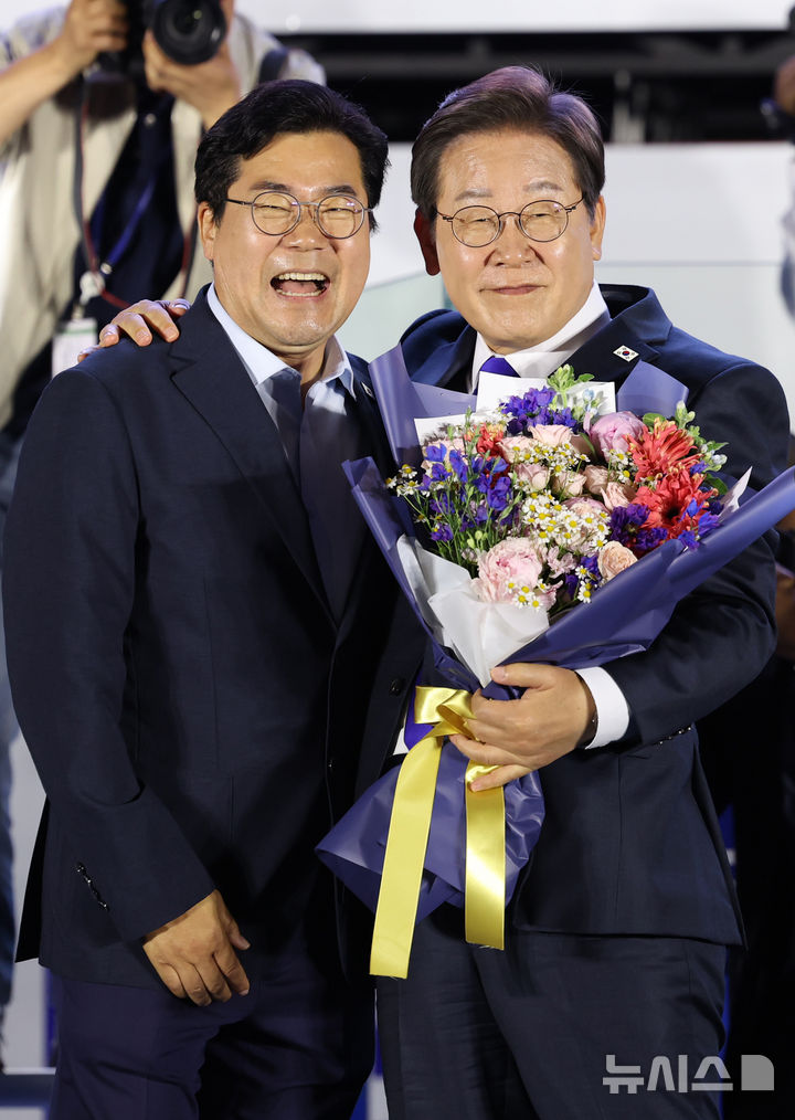 [서울=뉴시스] 조성우 기자 = 이재명 대통령이 4일 오전 서울 여의도 국회 앞에서 열린 국민 개표방송 행사에서 박찬대 더불어민주당 상임 총괄선거대책위원장에게 꽃다발을 받고 미소짓고 있다. 2025.06.04. xconfind@newsis.com