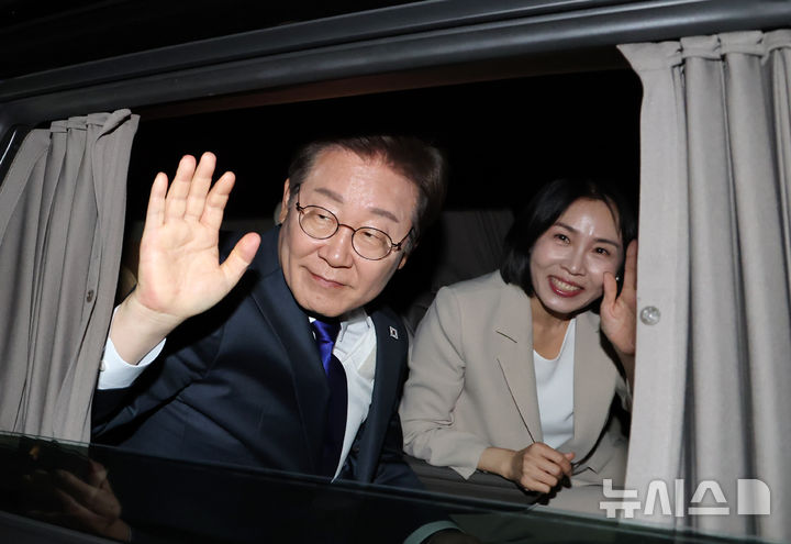 [서울=뉴시스] 조성우 기자 = 이재명 대통령과 김혜경 여사가 4일 오전 서울 여의도 국회 앞에서 국민 개표방송 행사를 마치고 차에서 손 인사를 하고 있다.(공동취재) 2025.06.04. photo@newsis.com