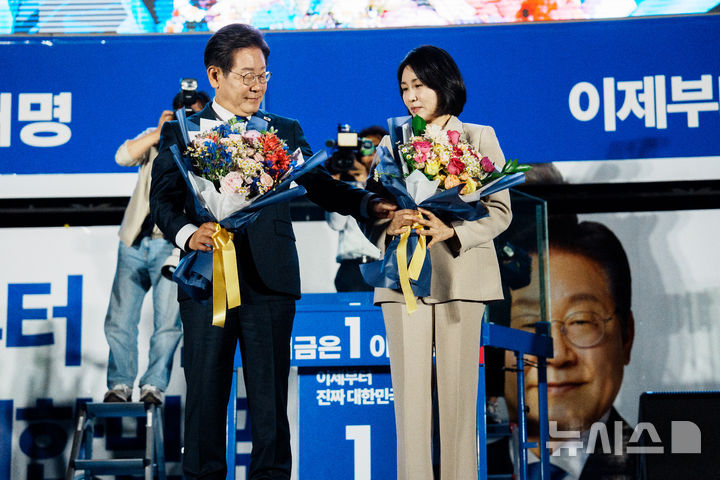 [서울=뉴시스] 조성우 기자 = 이재명 대통령과 김혜경 여사가 4일 오전 서울 여의도 국회 앞에서 열린 국민 개표방송 행사에서 꽃다발을 받고 있다. (공동취재) 2025.06.04. photo@newsis.com
