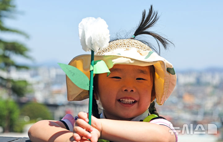 [대구=뉴시스] 이무열 기자 = 현충일을 이틀 앞둔 4일 대구 남구 충혼탑을 찾은 한 어린이가 직접 만든 종이 국화로 헌화하고 있다. 2025.06.04. lmy@newsis.com