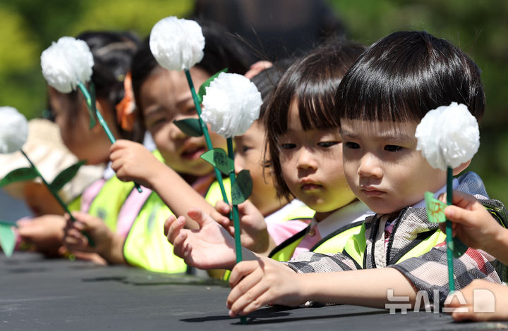 [대구=뉴시스] 이무열 기자 = 현충일을 이틀 앞둔 4일 대구 남구 충혼탑을 찾은 어린이들이 직접 만든 종이 국화로 헌화하고 있다. 2025.06.04. lmy@newsis.com