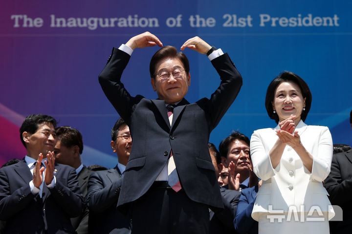 [서울=뉴시스] 조성우 기자 = 이재명 대통령 내외가 4일 오전 서울 여의도 국회 로텐더홀에서 취임 선서를 마치고 나와 잔디광장에 모인 시민들을 향해 하트를 만들어 보이고 있다. 2025.06.04. xconfind@newsis.com
