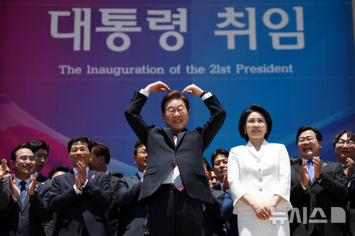 [서울=뉴시스] 조성우 기자 = 이재명 대통령 내외가 4일 오전 서울 여의도 국회 로텐더홀에서 취임 선서를 마치고 나와 잔디광장에 모인 시민들을 향해 하트를 만들어 보이고 있다. 2025.06.04. xconfind@newsis.com
