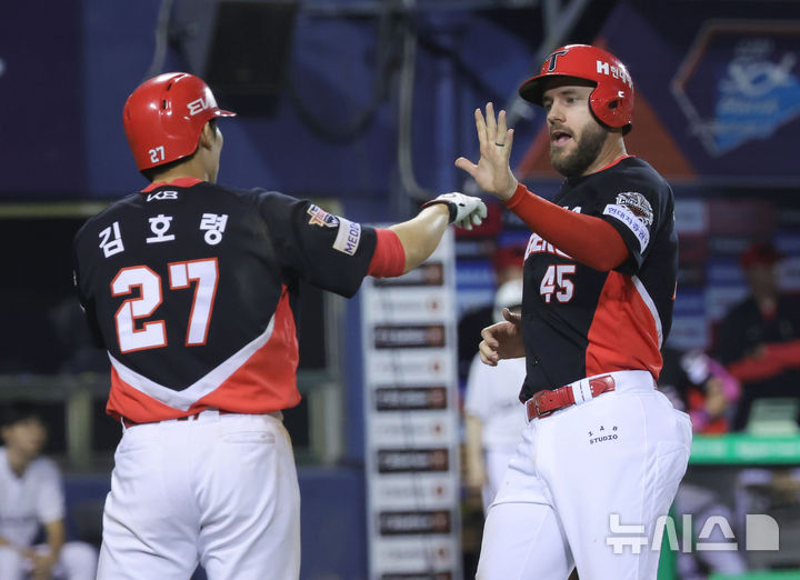 [서울=뉴시스] 홍효식 기자 = 4일 서울 송파구 잠실야구장에서 열린 2025 KBO리그 KIA 타이거즈와 두산 베어스의 경기, 8회초 1사 2,3루 KIA 김태군의 희생플라이 아웃 때 홈인한 위즈덤이 다음 타석인 김호령과 기뻐하고 있다. 2025.06.04. yesphoto@newsis.com