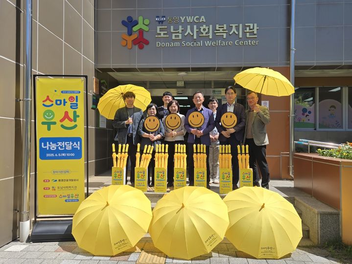 [통영=뉴시스] 신정철 기자= 통영관광개발공사는 생활밀착형 공공서비스 확대를 위해 도남사회복지관과 손잡고 ‘마을 공유 스마일 우산 캠페인’을 시작했다고 5일 밝혔다.사진은 통영관광개발공사가 도남사회복지관 앞에서 230만원을 들여 전개하고 있는 스마일 우산 캠페인 모습.(사진= 통영관광개발공사 제공).2025.06.05. photo@newsis.com *재판매 및 DB 금지