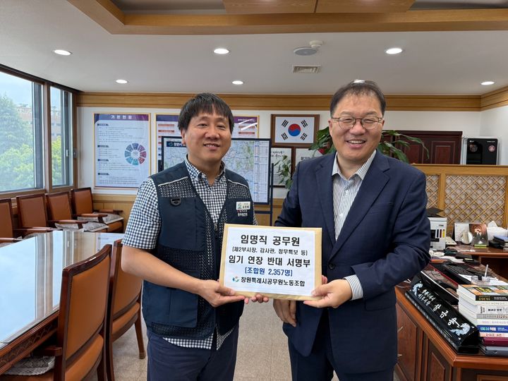 [창원=뉴시스] 강경국 기자 = 손민배 경남 창원시 공무원노동조합 위원장(왼쪽)이 5일 장금용 창원시장 권한대행에게 전임 시장이 임명한 임명직 공무원의 임기 연장 반대 조합원 서명부를 전달하고 있다. (사진=독자 제공). 2025.06.05. photo@newsis.com *재판매 및 DB 금지