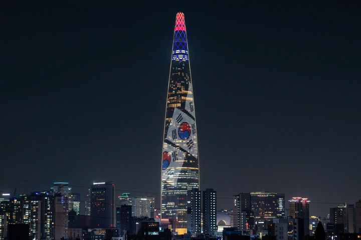 [서울=뉴시스] 롯데월드타워는 현충일(6월 6일)을 맞아 외벽 미디어파사드에 현충일의 의미를 되새길 수 있는 콘텐츠를 선보인다고 5일 밝혔다. 이번 콘텐츠는 6일 오후 8시부터 10시까지 매 정각부터 10분 단위로 송출되며, 태극기가 휘날리는 장면과 거대한 태극 문양을 번갈아 연출하여 순국선열과 호국영령의 뜻을 기린다. (사진=롯데물산 제공) 2025.06.05. photo@newsis.com *재판매 및 DB 금지