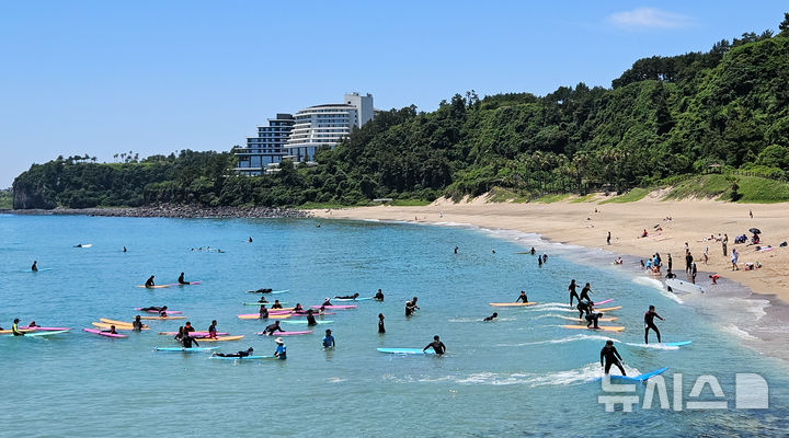 [서귀포=뉴시스] 우장호 기자 = 여름 날씨를 보인 5일 제주 서귀포시 중문색달해수욕장에서 물놀이객이 서핑을 배우며 즐거운 시간을 보내고 있다. 2025.06.05. woo1223@newsis.com