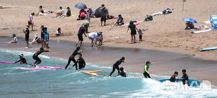 [서귀포=뉴시스] 우장호 기자 = 여름 날씨를 보인 5일 제주 서귀포시 중문색달해수욕장에서 물놀이객이 서핑을 배우며 즐거운 시간을 보내고 있다. 2025.06.05. woo1223@newsis.com