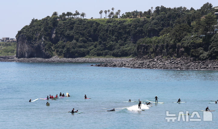 [서귀포=뉴시스] 우장호 기자 = 여름 날씨를 보인 5일 제주 서귀포시 중문색달해수욕장에서 물놀이객이 서핑을 배우며 즐거운 시간을 보내고 있다. 2025.06.05. woo1223@newsis.com
