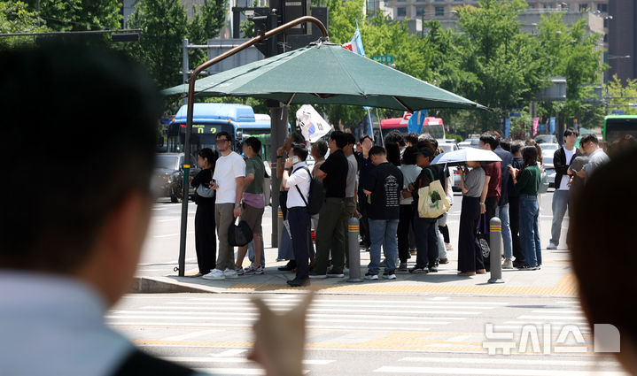[서울=뉴시스] 추상철 기자 = 절기상 망종에 초여름 날씨가 이어진 5일 오후 서울 종로구 세종대로사거리에서 시민들이 그늘막 아래에 모여 횡단보도 신호를 기다리고 있다. 2025.06.05. scchoo@newsis.com