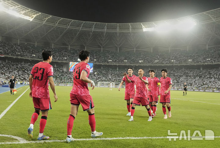 [바스라=AP/뉴시스] 오현규(오른쪽)가 5일(현지 시간) 이라크 바스라 국제경기장에서 열린 2026 국제축구연맹(FIFA) 북중미월드컵 아시아 3차 예선 B조 9차전 이라크와 경기 후반 37분 전진우(왼쪽)의 도움으로 추가 골을 넣고 동료들과 환호하고 있다. 한국이 이라크를 2-0으로 꺾고 11회 연속 월드컵 본선 진출을 확정했다. 2025.06.06.