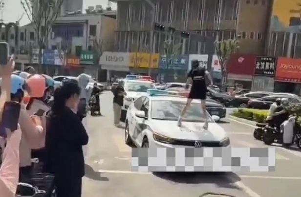 [서울=뉴시스]중국 산둥성 허쩌시에서 한 여성 인플루언서가 불법주차 단속에 항의하며 경찰차 위에 올라가 소란을 피워 논란이 일고 있다.(사진=광명왕) *재판매 및 DB 금지