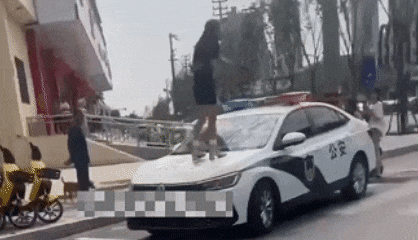 [서울=뉴시스]중국 산둥성 허쩌시에서 한 여성 인플루언서가 불법주차 단속에 항의하며 경찰차 위에 올라가 소란을 피워 논란이 일고 있다.(사진=광명왕) *재판매 및 DB 금지