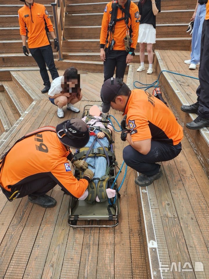 [서귀포=뉴시스] 6일 제주소방안전본부에 따르면 이날 오후 1시께 현충일 연휴를 맞아 제주를 방문한 60대 여성 A씨가 성산일출봉 정상에서 급성뇌경색 증상을 보인다는 신고가 119에 접수됐다. 현장에 출동한 구조대가 헬기 이송 준비를 하고 있다. (사진=제주도소방안전본부 제공) 2025.06.06. photo@newsis.com *재판매 및 DB 금지