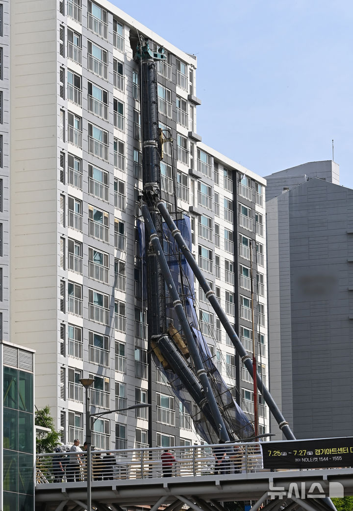 [용인=뉴시스] 김종택 기자 = 6일 경기 용인시 기흥구 서천동 인덕원~동탄 복선전철 공사 현장에서 중장비인 천공기(지반을 뚫는 건설기계)가 15층 높이 아파트 벽면에 기댄 모습으로 쓰러져 있다. 2025.06.06. jtk@newsis.com