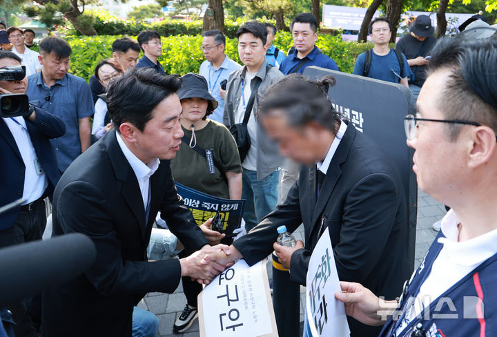 [서울=뉴시스] 고범준 기자 = 강훈식 대통령 비서실장이 6일 서울 용산 전쟁기념관 앞에서 태안화력발전소 사고 희생자와 관련해 요구안 서한을 받기 전 유족의 손을 잡고 있다. (대통령실통신사진기자단) 2025.06.06. bjko@newsis.com