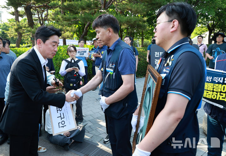 [서울=뉴시스] 고범준 기자 = 강훈식 대통령 비서실장이 6일 서울 용산 전쟁기념관 앞에서 태안화력발전소 사고 희생자 고(故) 김충현 씨와 관련해 엄길용 공공운수노조 위원장, 유족, 사고 대책위 관계자로부터 요구안 서한을 직접 받고 있다. (대통령실통신사진기자단) 2025.06.06. bjko@newsis.com