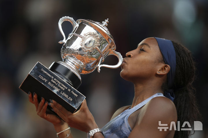 [파리=AP/뉴시스] 코코 고프(2위·미국)가 7일(현지 시간) 프랑스 파리 롤랑가로스 스타디움에서 열린 프랑스오픈 여자 단식 정상에 올라 트로피를 들고 입 맞추고 있다. 고프는 결승에서 아리나 사발렌카(1위·벨라루스)에게 2-1(6-7 6-2 6-4) 역전승을 거두고 생애 처음으로 프랑스 오픈 우승컵을 들어 올렸다. 2025.06.08. 