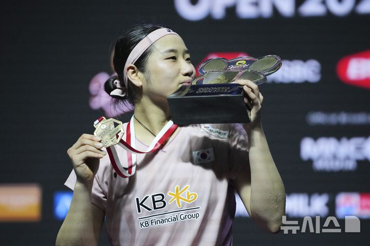 [자카르타=AP/뉴시스] 안세영(1위)이 8일(현지시간) 인도네시아 자카르타 이스토라 스타디움에서 열린 세계배드민턴연맹(BWF) 월드투어 슈퍼 1000 인도네시아 오픈 여자 단식 정상에 올라 트로피를 들고 입 맞추고 있다. 안세영은 결승에서 왕즈이(2위·중국)를 2-1(13-21 21-19 21-15)로 물리치고 4년 만에 정상을 탈환했다. 2025.06.08.