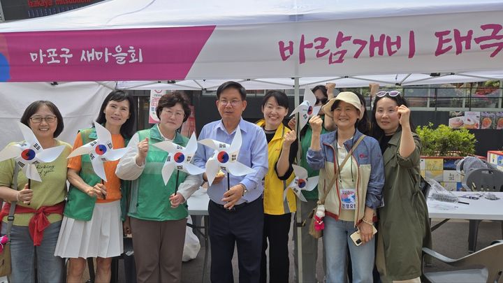 [서울=뉴시스] 박강수 마포구청장이 한반도 대축제에서 태극기 바람개비를 들고 기념촬영을 하고 있다. 2025.06.08. (사진=마포구 제공) *재판매 및 DB 금지
