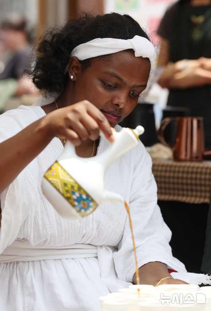 [서울=뉴시스] 김진아 기자 = 8일 서울 노원구 공릉역 일대에서 열린 '제3회 경춘선 공릉숲길 커피축제'에서 에티오피아의 분나 마프라트 시연이 열리고 있다.&nbsp; '커피 여행'을 주제로 열린 이번 축제에서는 케냐, 과테말라, 엘살바도르 등 세계 20여 개국의 커피를 맛보고 각국의 고유한 커피 문화도 체험해볼 수 있다. 2025.06.08. bluesoda@newsis.com