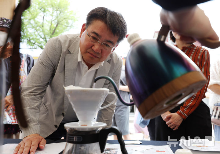 [서울=뉴시스] 김진아 기자 = 오승록 노원구청장이 8일 서울 노원구 공릉역 일대에서 열린 '제3회 경춘선 공릉숲길 커피축제'에서 카메룬 블루마운틴 공정무역커피에 대한 설명을 듣고 있다.&nbsp;&nbsp; '커피 여행'을 주제로 열린 이번 축제에서는 케냐, 과테말라, 엘살바도르 등 세계 20여 개국의 커피를 맛보고 각국의 고유한 커피 문화도 체험해볼 수 있다. 2025.06.08. bluesoda@newsis.com